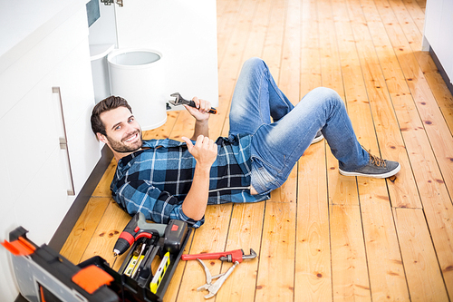 Portrait of man fixing kitchen sink giving thumbs up in the kitchen