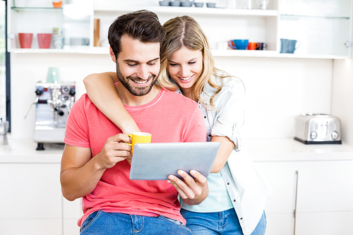 Young couple using digital tablet in the kitchen