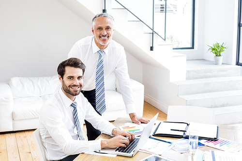 Businessmen discussing office work on laptop in office