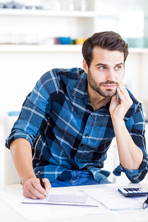 A businessman is posing and holding a pen in his hand at work