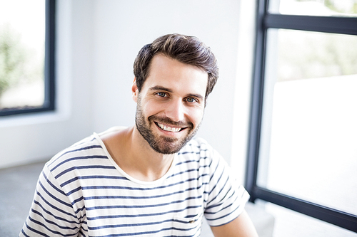 Portrait of happy man sitting on steps at home