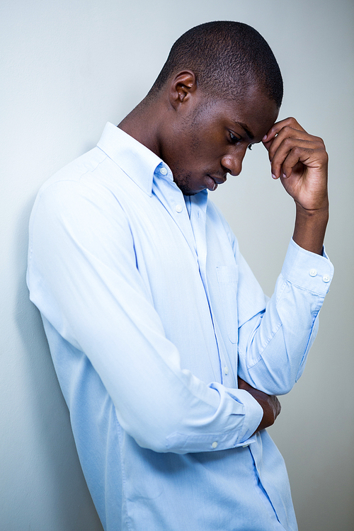 Tensed man leaning on wall at home