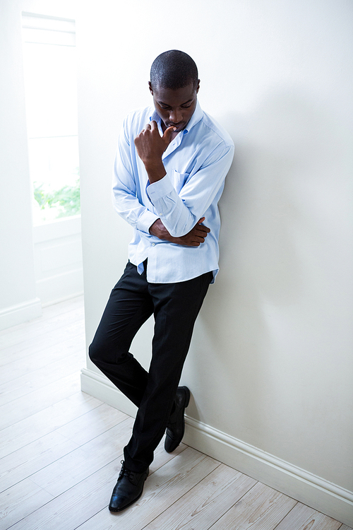 Tensed man leaning on wall at home