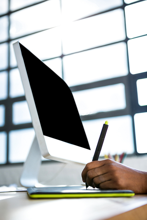 Graphic designer working on her graphics tablet in office