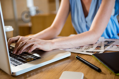 Woman in office sitting at desk using laptop