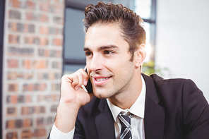 Close-up of smart businessman talking on mobile phone in office