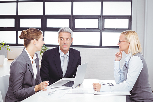 Business people discussing with client at desk in meeting room