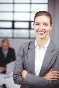 Close-up portrait of businesswoman smiling while business people in background