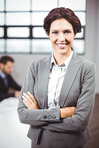 Portrait of beautiful confident businesswoman with arms crossed standing in office