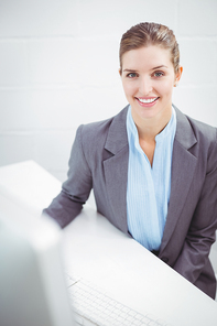 Portrait of happy businesswoman sitting at desk in office