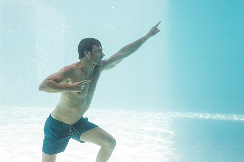 Cheerful man gesturing while standing underwater