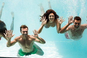 Cheerful friends swimming underwater