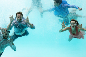 Happy friends swimming in pool at resort