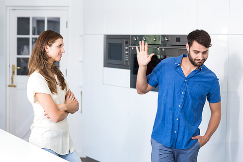 Man doing stop gesture to wife while arguing at home