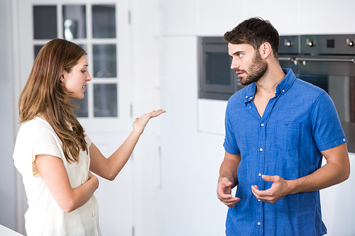 Young couple arguing in kitchen at home