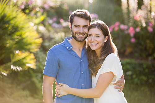 Portrait of couple embracing while standing at park