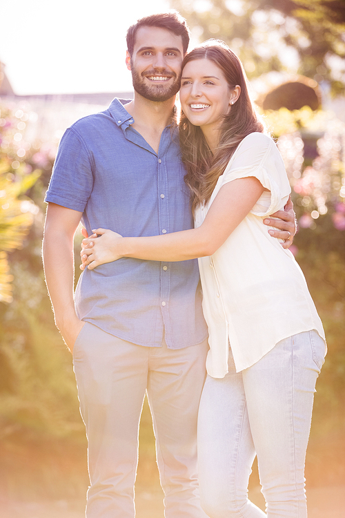 Young couple embracing and standing at park