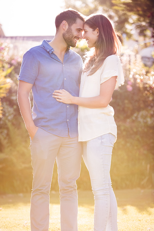 Couple embracing and romancing while standing at park