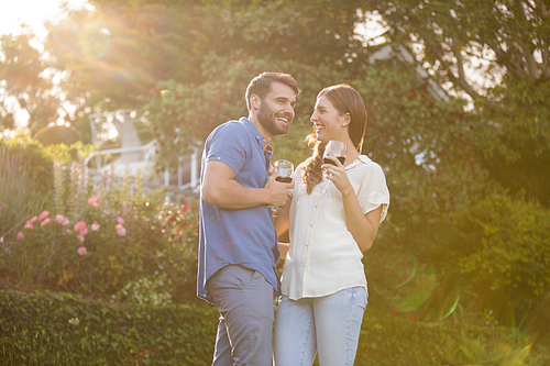 Young couple standing with wineglass at park