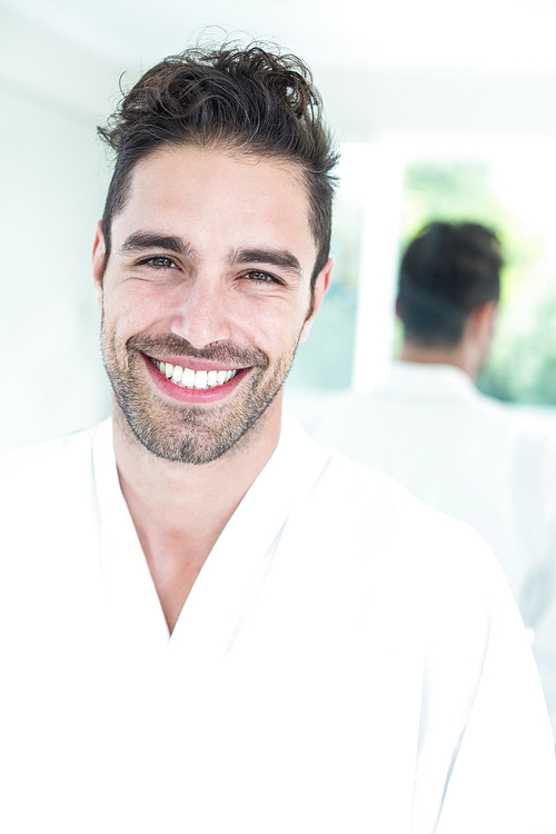 Portrait of happy handsome man against mirror at home