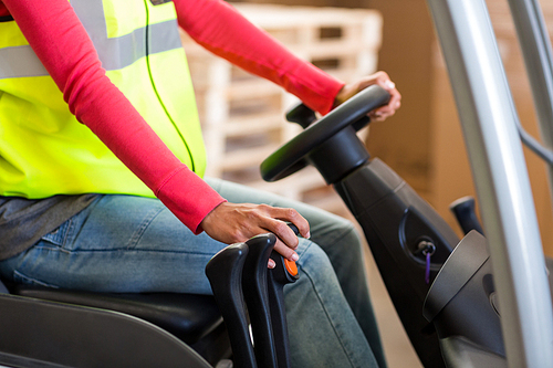 Close up of worker is driving a pallet truck in a warehouse