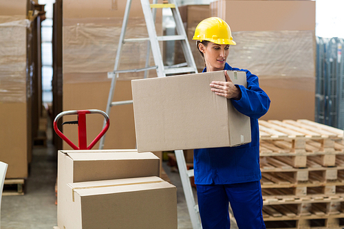 Female worker carrying a box in warehouse