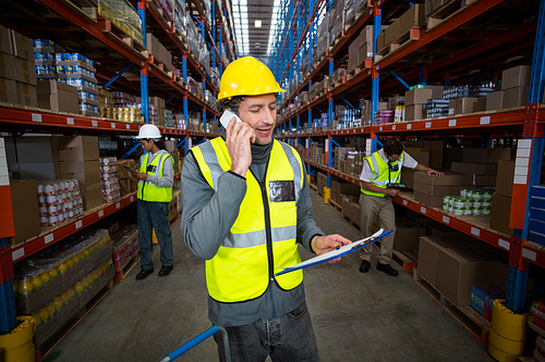 Worker using phone in warehouse