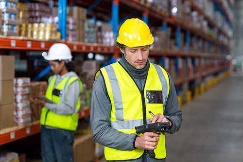 Worker checking stock with digital equipment in warehouse