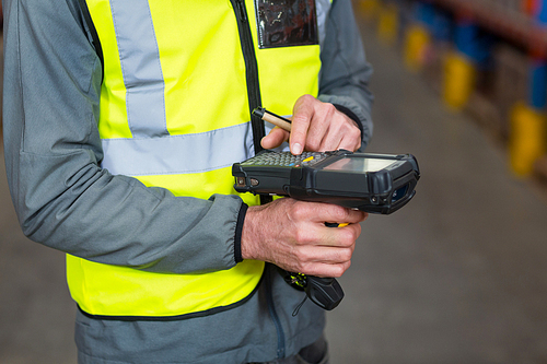 Close-up of worker using digital equipment in warehouse