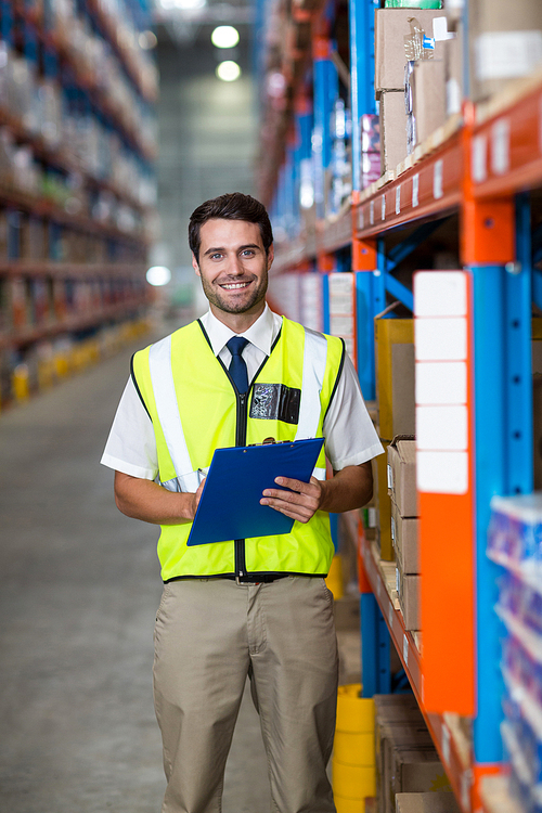 Worker with clipboard  in warehouse
