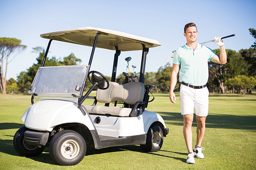 Full length of man standing by golf buggy on field