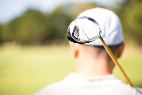 Focus on foreground of golf club behind the neck of golfer
