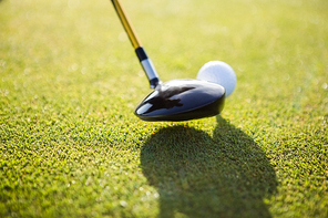 Close up of a golf ball and club on field
