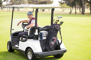 Golfer smiling and posing in his golf buggy