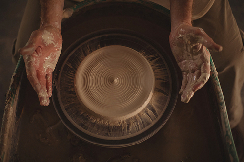 Hands of potter making a pot in pottery workshop