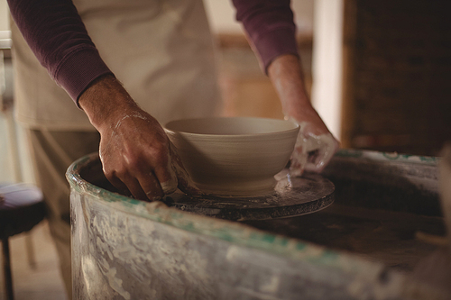 Male potter making bowl in pottery workshop