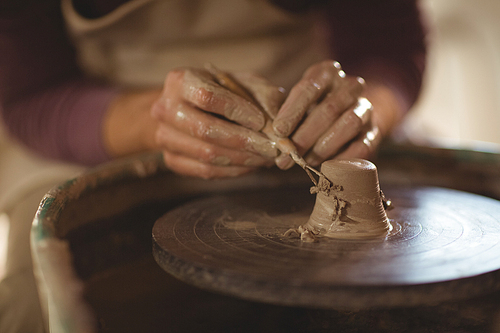 Close-up of potter working on bowl in pottery workshop