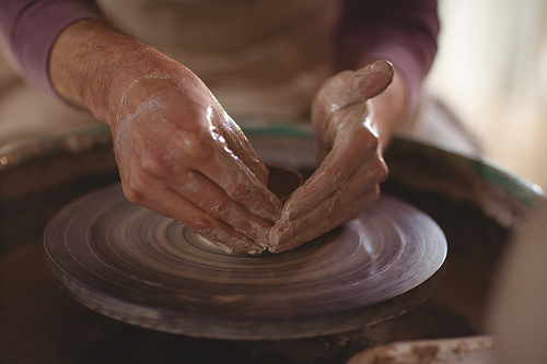 Close-up of male potter making bowl in pottery workshop