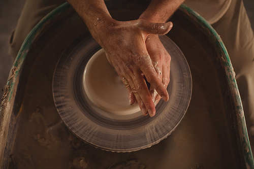 Close-up of male potter making pot in pottery workshop