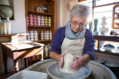 Female potter making pot in pottery workshop
