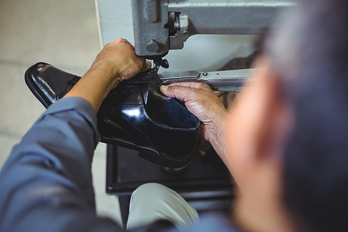 Shoemaker using sewing machine in workshop