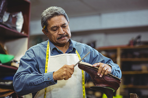 Shoemaker repairing a shoe in workshop
