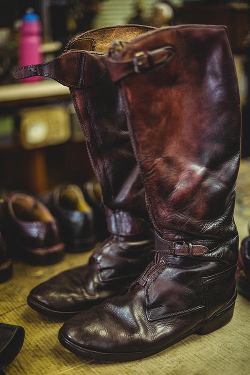 Pair of long leather boots in workshop