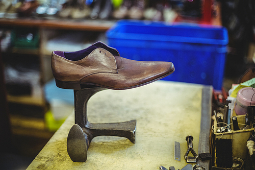 Leather shoe on shoe repair stand in workshop