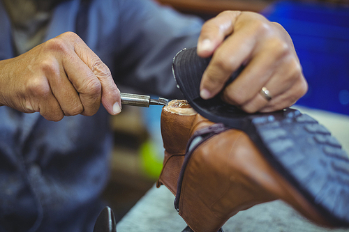Shoemaker repairing a shoe sole in workshop