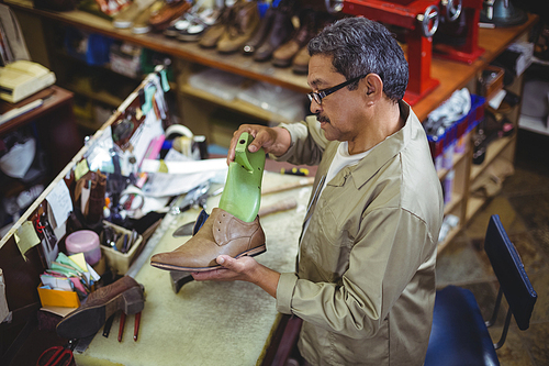 Shoemaker repairing a shoe sole in workshop