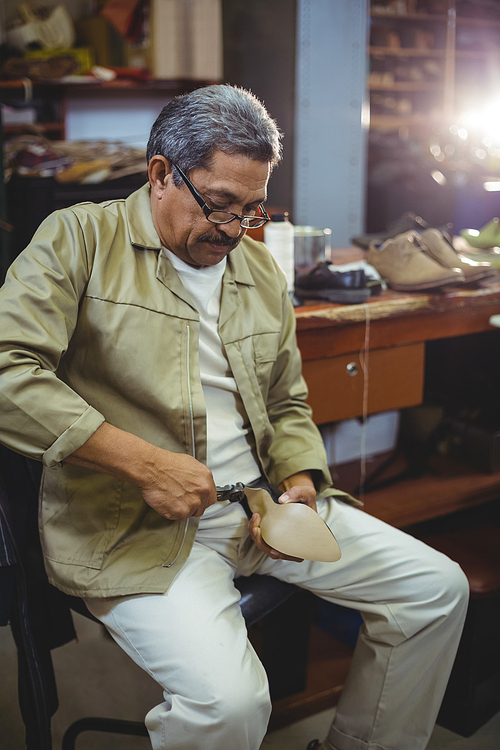 Shoemaker repairing a high heel in workshop