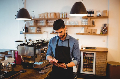 Young man using digital tablet at office cafeteria