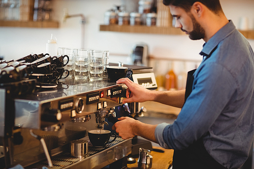 Man taking coffee from espresso machine in office cafeteria