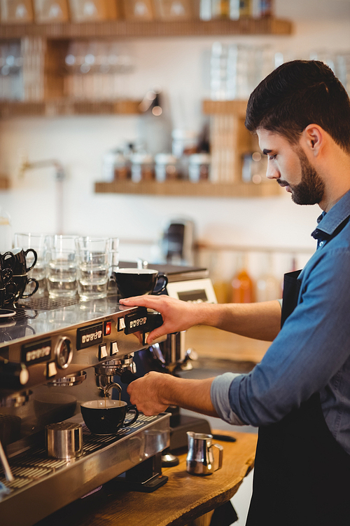 Man taking coffee from espresso machine in office cafeteria